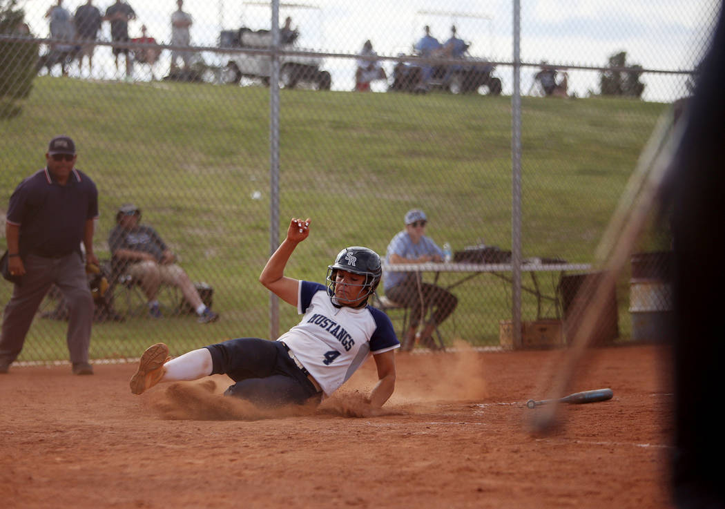 Shadow Ridge High School's Shea Clements (4) slides to make home base against Centennial High S ...