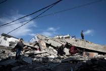 Palestinians check the damage of a multi-story building following Israeli airstrikes in Gaza Ci ...