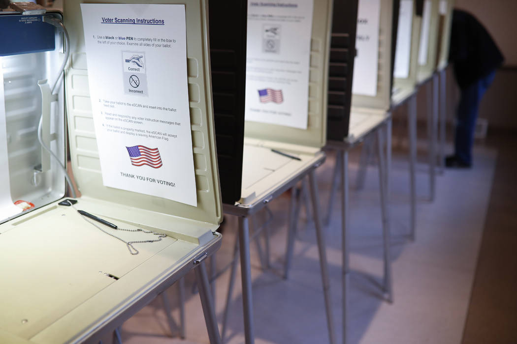 FILE- In this Nov. 8, 2016, file photo a lone voter fills out a ballot alongside a row of empty ...
