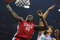 UNLV Rebels forward Jonathan Tchamwa Tchatchoua (30) takes a shot while under pressure from Nev ...