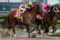 Luis Saez rides Maximum Security, center, crosses the finish line first ahead of Country House, ...