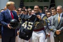 President Donald Trump accepts a jersey from Army running back Darnell Woolfolke Army during th ...