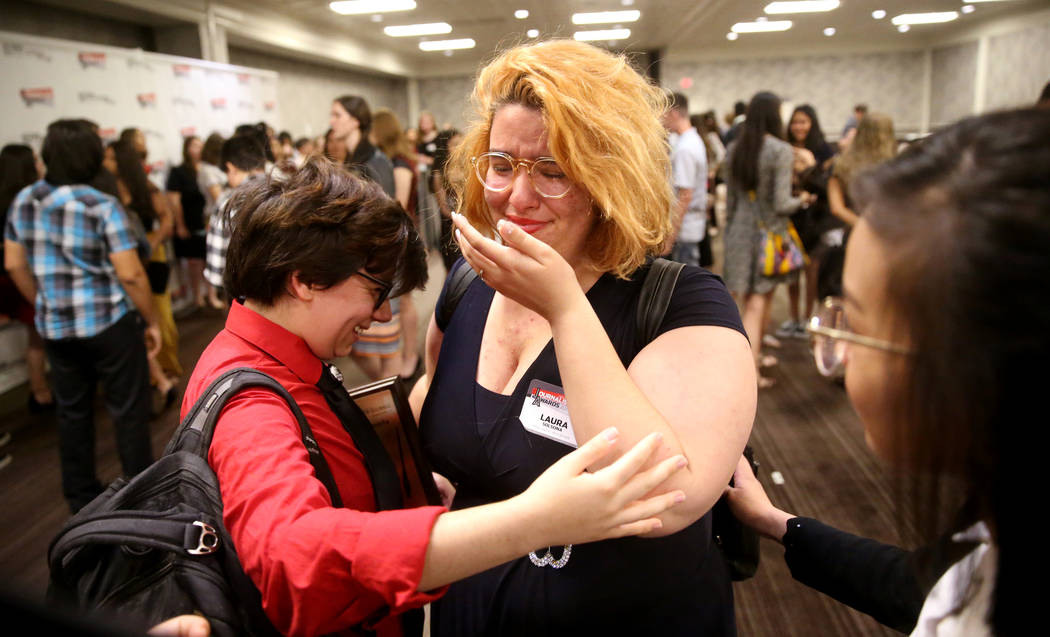 Laura Solsona of Spring Valley High School newspaper, The Grizzly Growler, center, cries with N ...