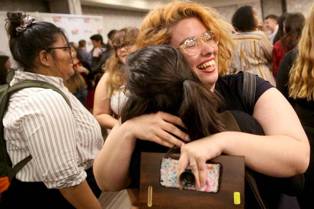 Laura Solsona of Spring Valley High School newspaper, The Grizzly Growler, facing, hugs Jessica ...