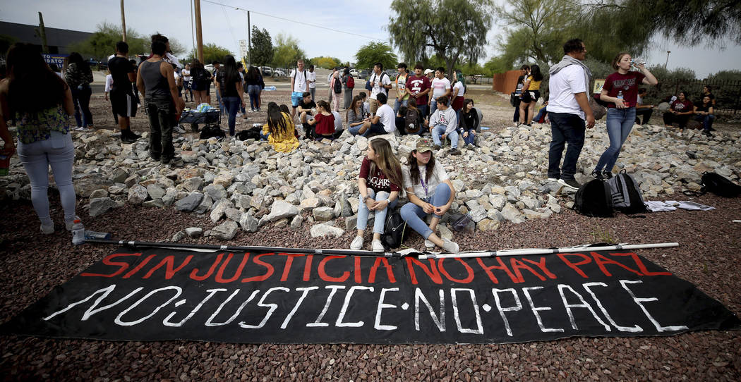 Students from Desert View High School sit by a banner after marching to the Pima County Sheriff ...