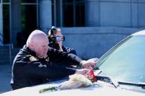 Biloxi Police Chief John Miller places flowers and a card on the police SUV of Officer Robert M ...