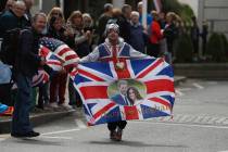 Royal fan John Loughery displays a banner as people wait for the Royal Regiment of Scotland ban ...