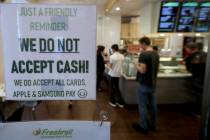 A sign posted on a door May 2, 2019, alerts customers that cash is not accepted at Freshroll Vi ...