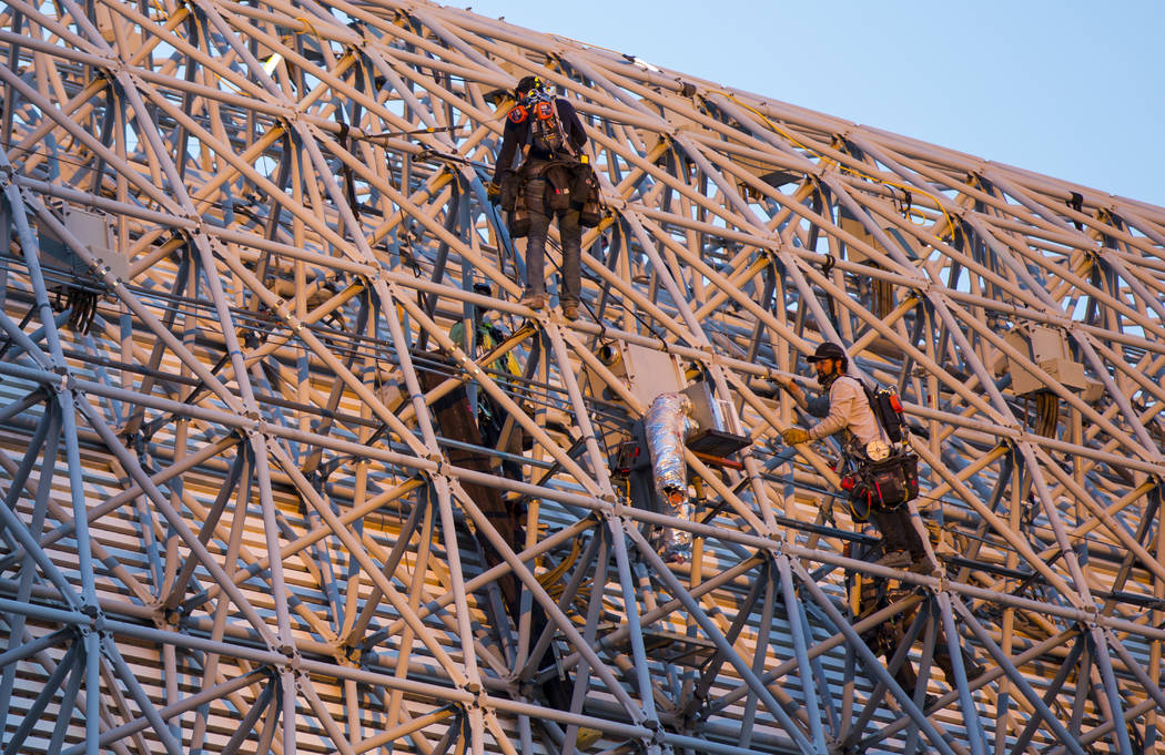 Construction workers work around the exterior of the canopy during the second day of renovation ...