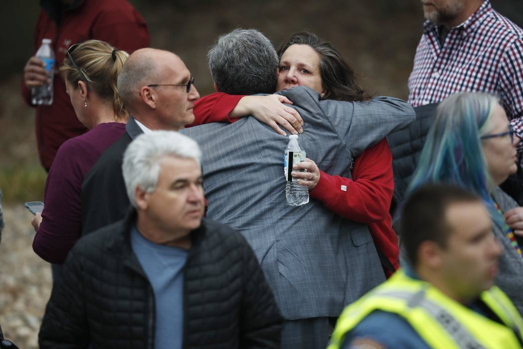 Parents hug as they wait for their children at a recreation center where students were reunited ...