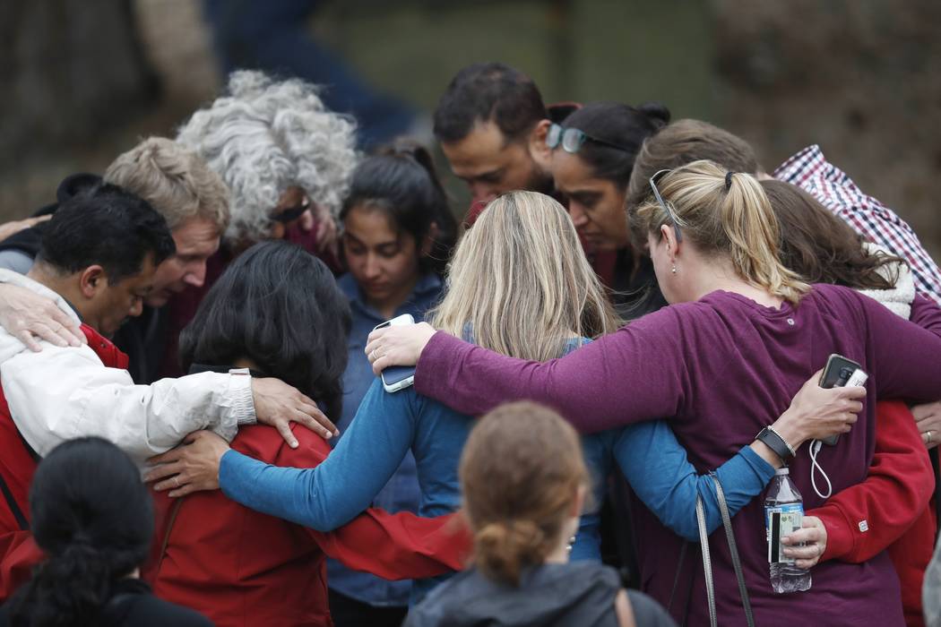 Parents gather in a circle to pray at a recreation center where students were reunited with the ...