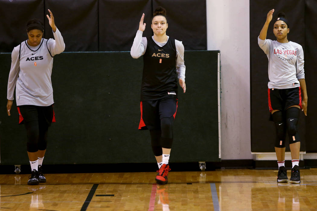 Las Vegas Aces guard Kayla McBride (21) center, stretches with teammates Alex Harden, left, and ...