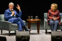 Former U.S. President Bill Clinton tells a story seated beside former U.S. Secretary of State H ...