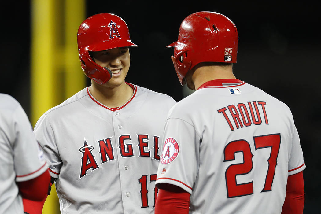 Los Angeles Angels' Shohei Ohtani, left, smiles at Mike Trout (27) after walking in the ninth i ...