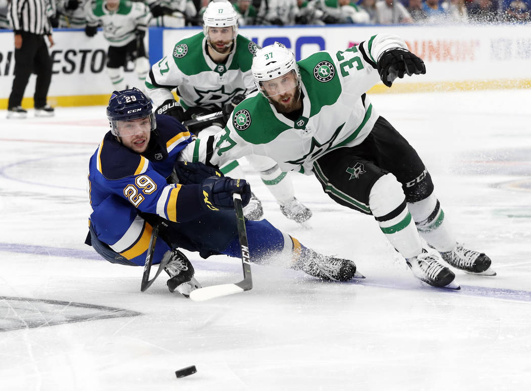 St. Louis Blues' Vince Dunn (29) and Dallas Stars' Justin Dowling (37) move to control the puck ...