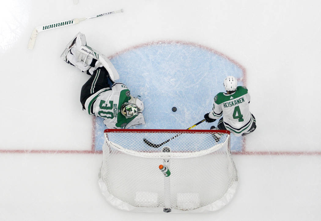 Dallas Stars' Ben Bishop (30) and Miro Heiskanen (4) lie by the net after giving up a score to ...
