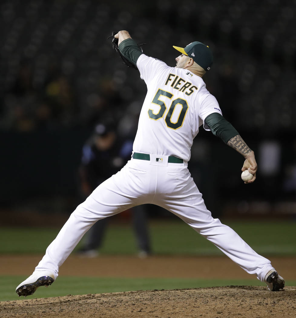 Oakland Athletics' Mike Fiers works against the Cincinnati Reds in the ninth inning of a baseba ...