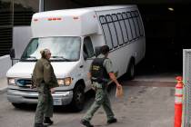 A van carrying asylum seekers from the border is escorted by security personnel as it arrives M ...