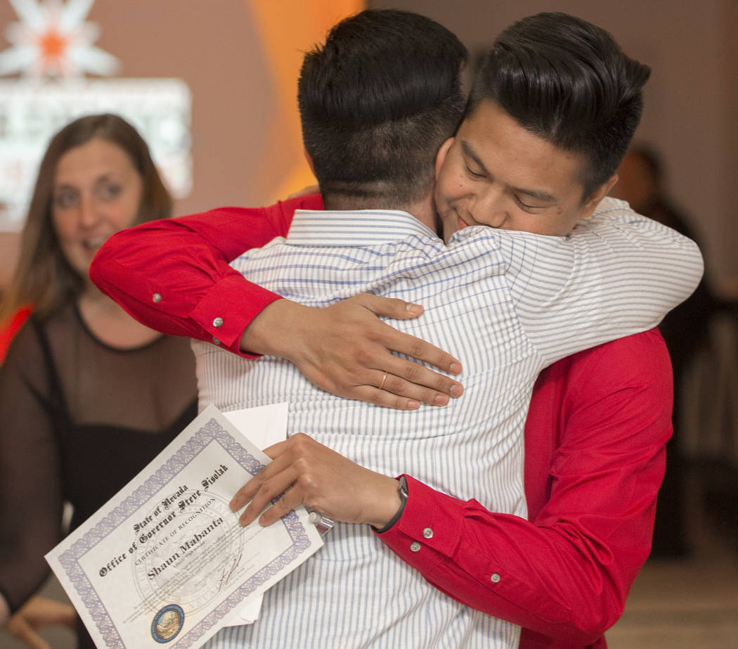 Award winner Shaun Mabanta, red shirt, a twelfth grader at Liberty High School, gets a big hug ...