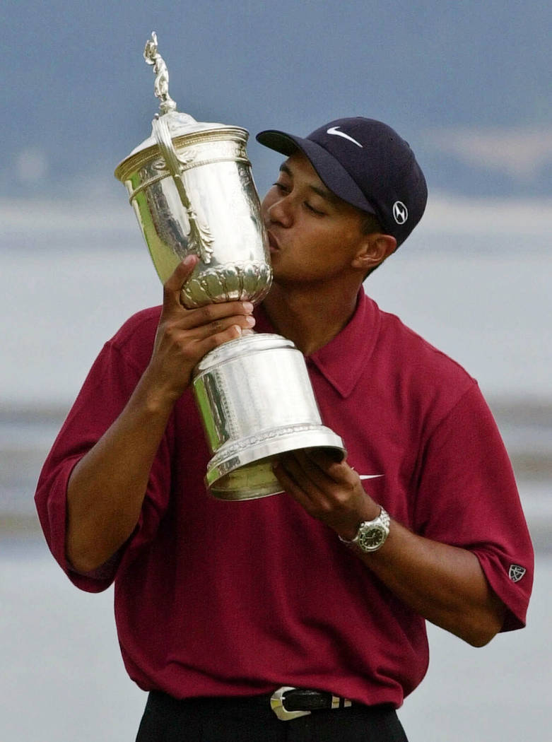 FILE - In this June 18, 2000, file photo, Tiger Woods kisses the winner's trophy after capturin ...