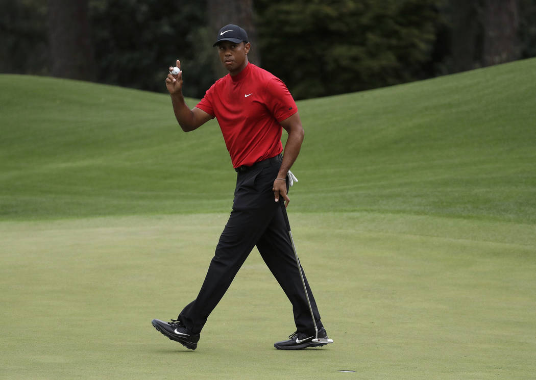 FILE - In this April 14, 2019, file photo, Tiger Woods waves on the eighth hole during the fina ...
