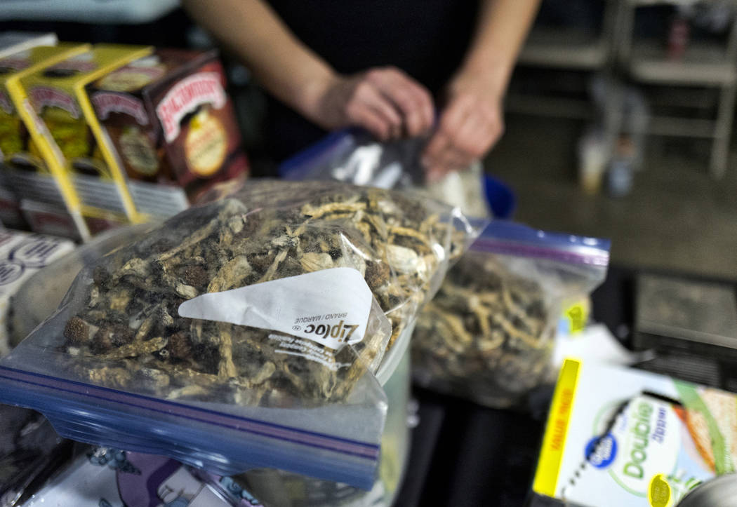A vendor bags psilocybin mushrooms at a pop-up cannabis market in Los Angeles on Monday, May 6, ...