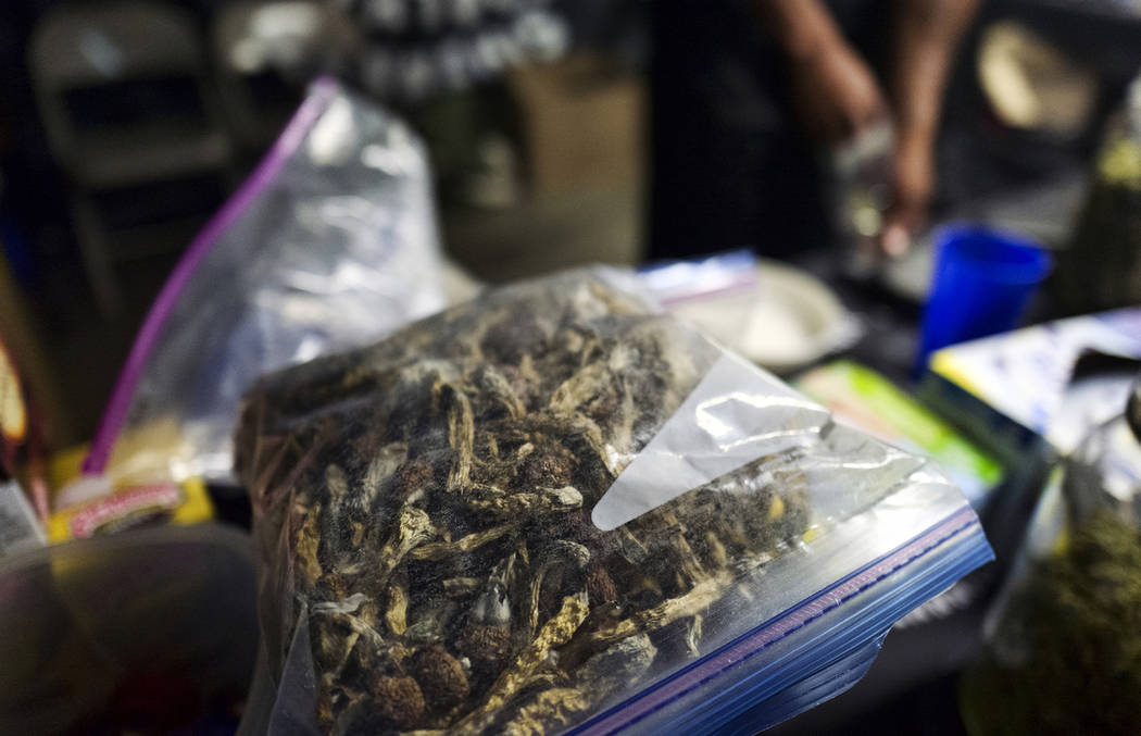 A vendor bags psilocybin mushrooms at a pop-up cannabis market in Los Angeles on Monday, May 6, ...