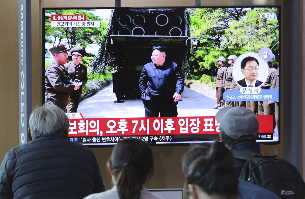 People watch a TV showing a file photo of North Korean leader Kim Jong Un, top center, during a ...
