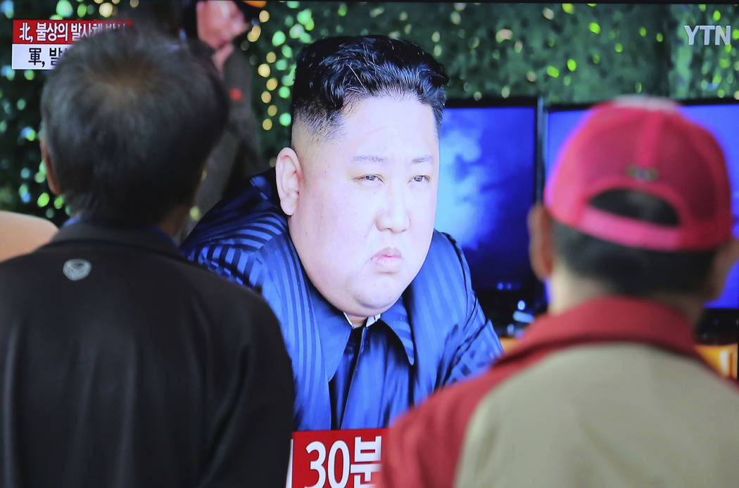 People watch a TV showing a file photo of North Korean leader Kim Jong Un during a news program ...