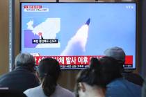 People watch a TV showing file footage of North Korea's missile launch during a news program at ...