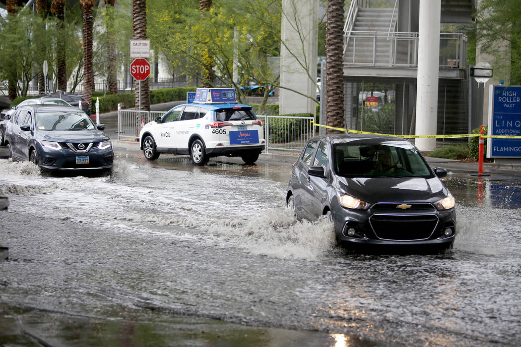 Cars drive through the flooding at The Linq parking garage in Las Vegas, April 29, 2019. (Rache ...
