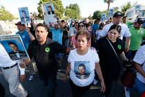 Edith Guzman, center, marches with community members including Pastor Luis Sanchez, left, and E ...