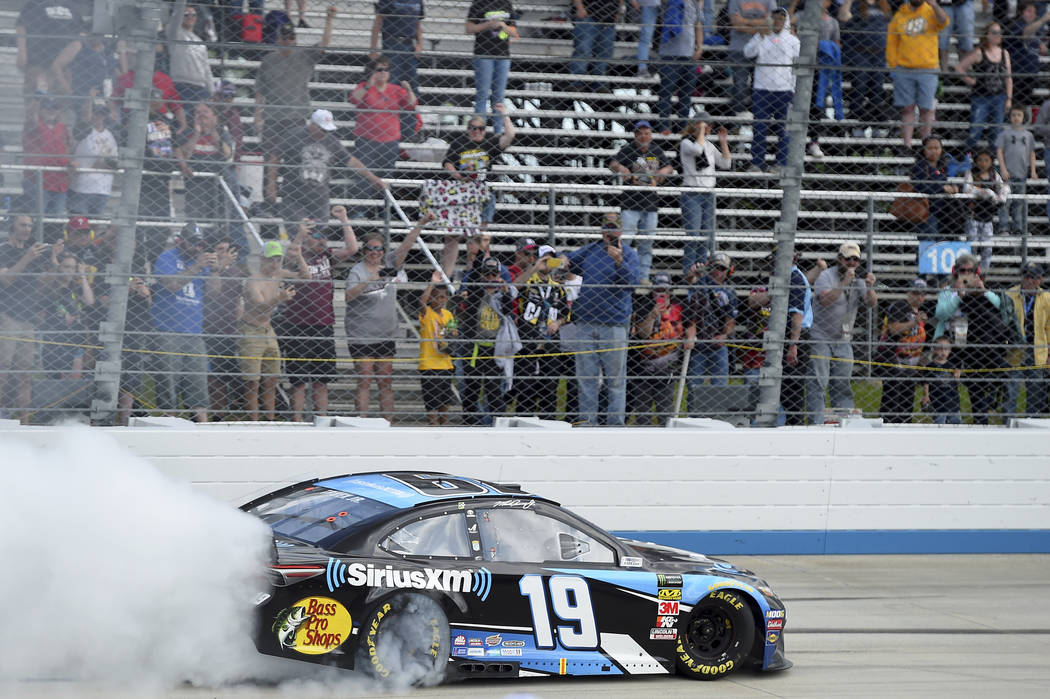 Driver Martin Truex Jr. (19) performs a burnout after winning a NASCAR Cup Series auto race, Mo ...