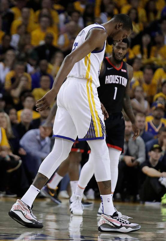 Golden State Warriors' Kevin Durant, center, limps off the court during the second half of Game ...