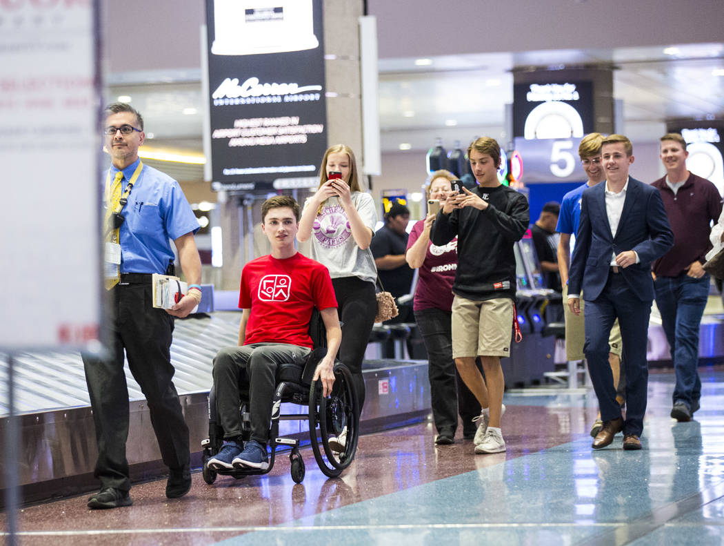 Faith Lutheran senior Mark Wilbourne, in red, reacts to a welcome party at McCarran Internation ...