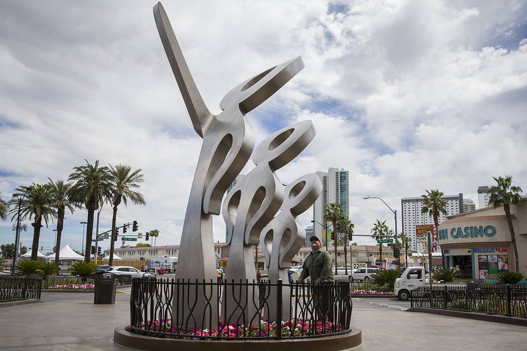 People walk by a new statue called "LOOK!" outside The Strat on Friday, April 19, 201 ...