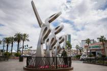 People walk by a new statue called "LOOK!" outside The Strat on Friday, April 19, 201 ...