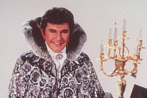 Liberace, wearing his shiny rings and dress, is shown 1987. (AP Photo)