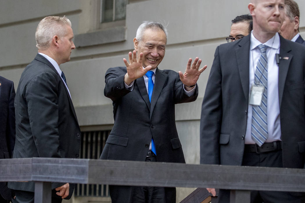 Chinese Vice Premier Liu He, center, waves to members of the media as he arrives at the Office ...