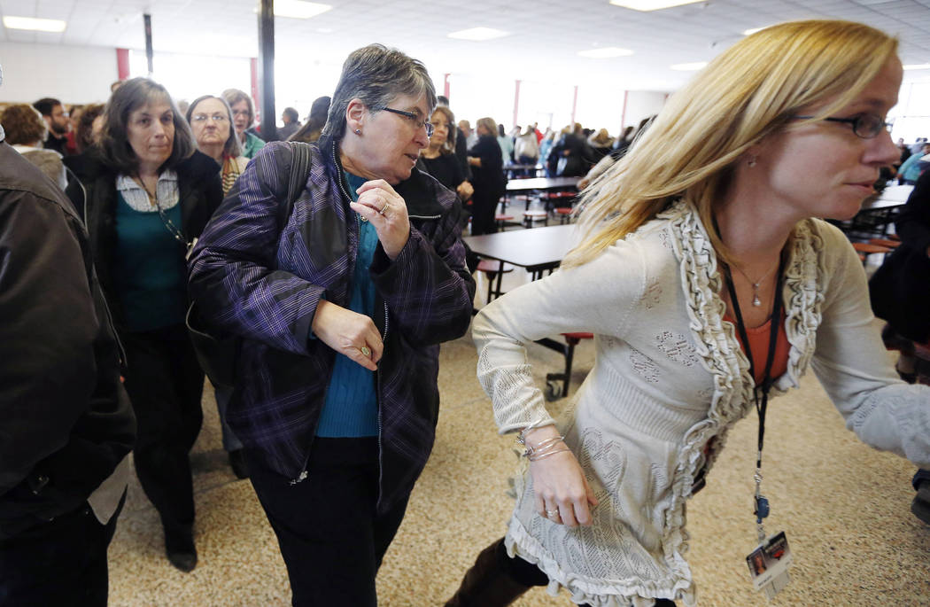 Participants rush out of the cafeteria after hearing gun shots during a lockdown exercise March ...