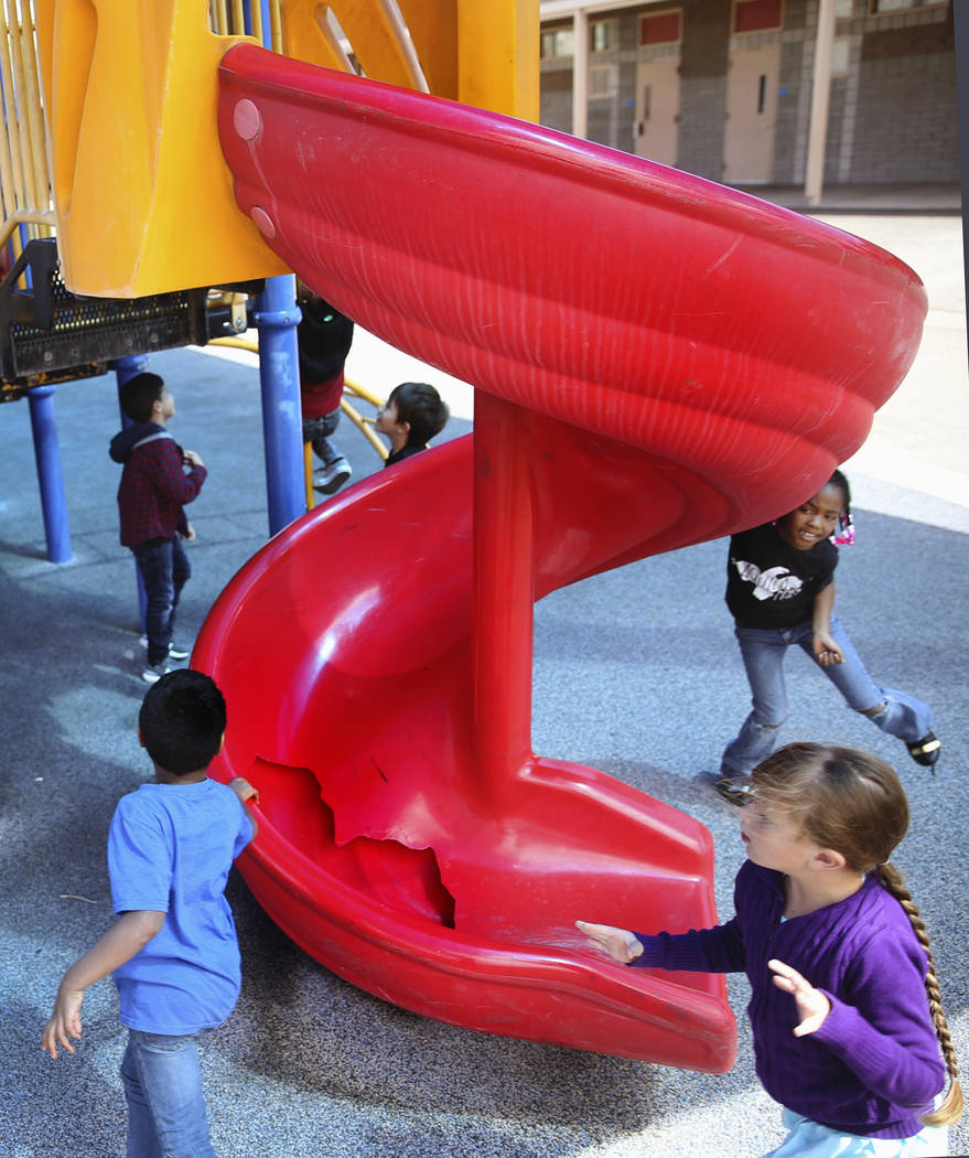 Students run around a broken slide in the playground at Helen Smith Elementary School in Las Ve ...