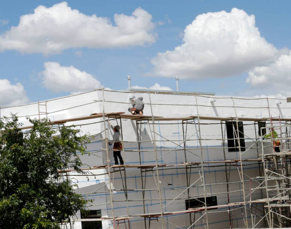 Workers construct houses near the corner of Mesa Park Drive and Hualapai Way in Summerlin, Frid ...