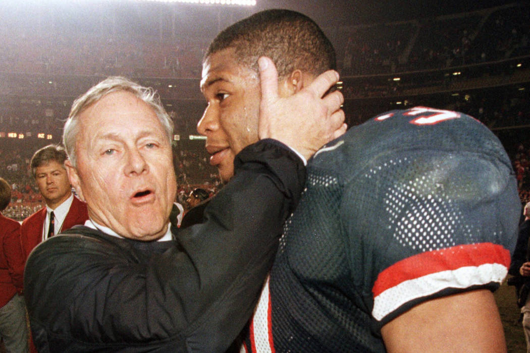 In this Dec. 30, 1998, file photo, Arizona coach Dick Tomey, left, congratulates linebacker DaS ...