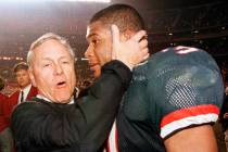 In this Dec. 30, 1998, file photo, Arizona coach Dick Tomey, left, congratulates linebacker DaS ...