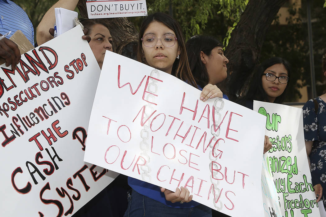 Annette Alvarez, middle, joins other protesters as they gather in front of Maricopa County Atto ...