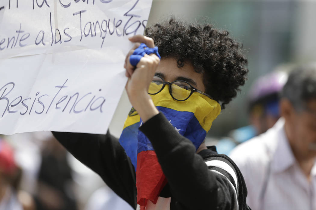 An opponent of the Nicolas Maduro government waits for the arrival of opposition leader Juan Gu ...