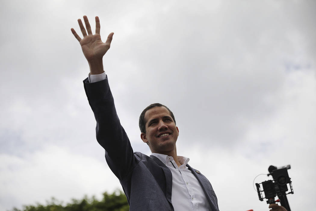 Opposition leader Juan Guaidó greets supporters as he arrives to lead a rally in Caracas, ...