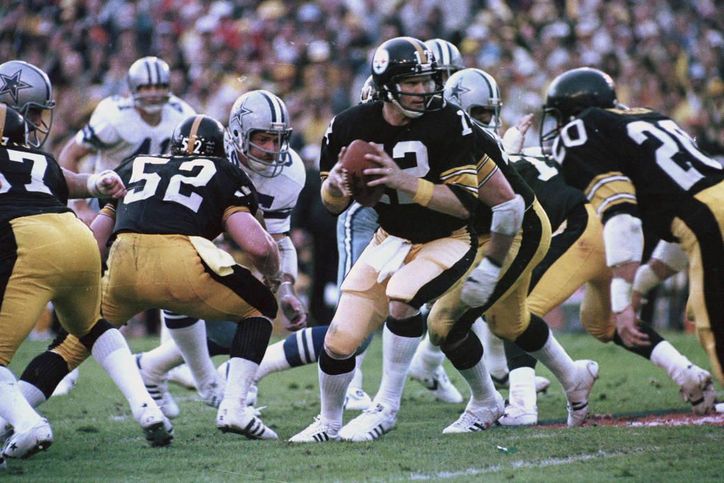 Pittsburgh Steelers quarterback Terry Bradshaw (12) turns around with the ball after the snap t ...
