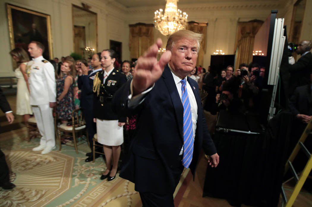 President Donald Trump waves as he leaves the East Room during a celebration of military mother ...