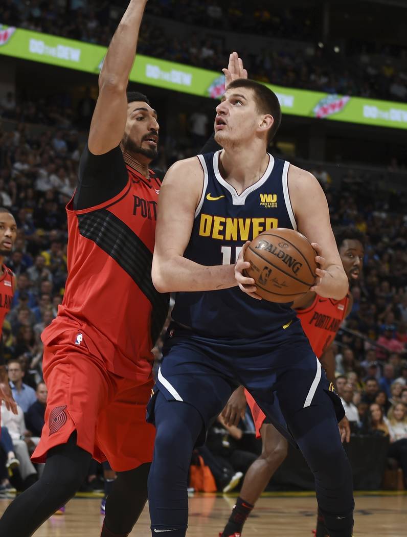 Denver Nuggets center Nikola Jokic, right, goes up for a basket Portland Trail Blazers center E ...